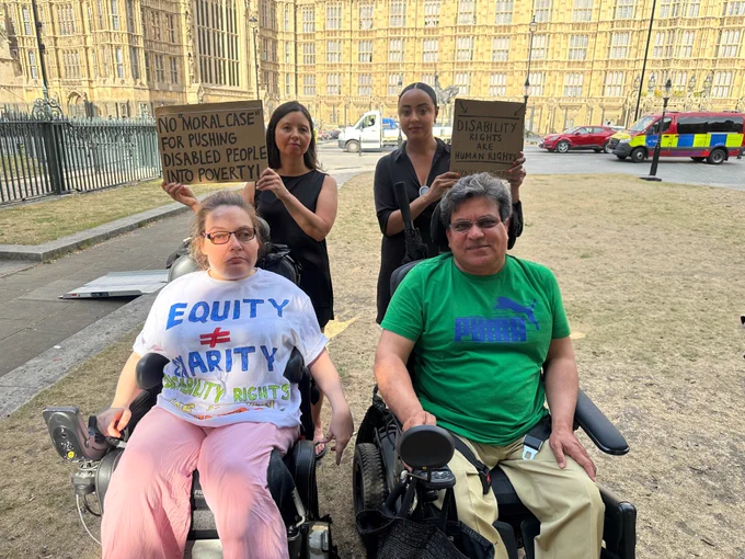 Three members of Merton CIL staff and a  campaigner outside the Houses of Parliament in Westminster. 