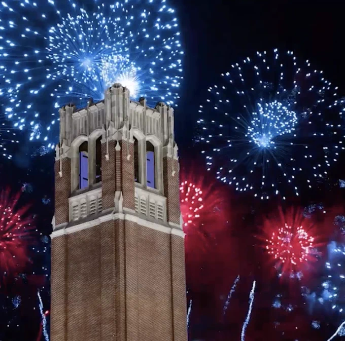 Blue and red fireworks shooting behind Century Tower. 