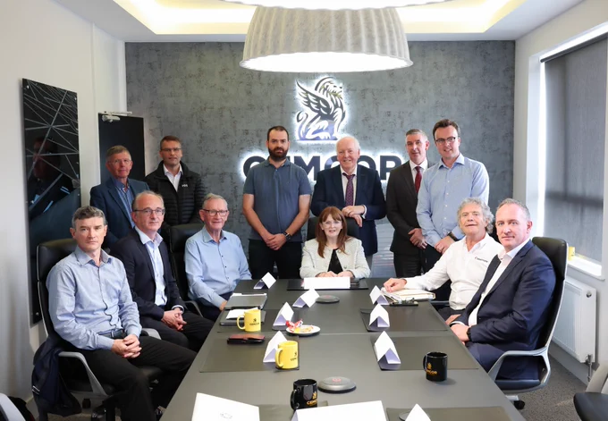 Photograph of Economy Minister Dr Caoimhe Archibald with representatives from the Mid Ulster Biorefinery and Circular Economy Cluster in the boardroom at Cemcor, Cookstown. 