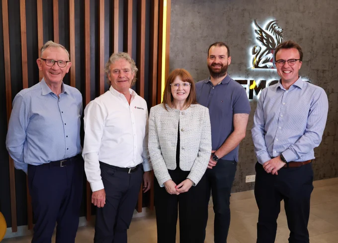 Photograph of Economy Minister Dr Caoimhe Archibald with representatives from the Mid Ulster Biorefinery and Circular Economy Cluster in the reception area of Cemcor, Cookstown.