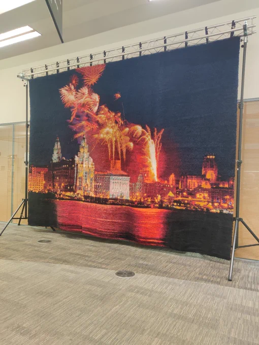 A huge hand-latched rug featuring a view of Liverpool Waterfront with fireworks 