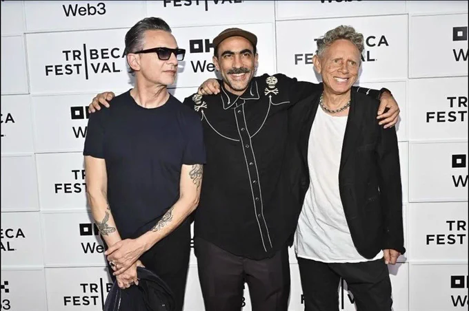 Fernando Frias stands between Andrew Fletcher and Martin Gore of Depeche Mode with the Tribeca Film festival background