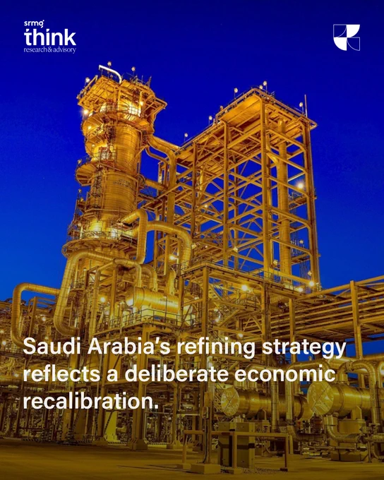 An illuminated oil refinery complex in Saudi Arabia glows against a deep blue evening sky. The image accompanies the headline “Saudi Arabia’s refining strategy reflects a deliberate economic recalibration,” highlighting the Kingdom’s strategic investment in downstream energy infrastructure.