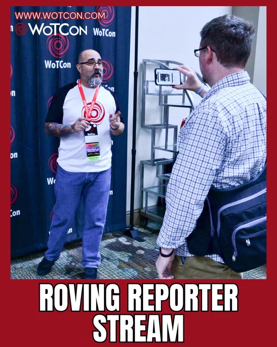 On a red background, bold white letters say "Roving reporter stream" at the bottom. Above it is a candid photo of Ta'veren Tavern (a white man with a shaved head and a salt and pepper goatee, wearing a black and white wotcon shirt, lanyard with wotcon badge, jeans, and black shoes) standing in front of a black backdrop with the wotcon logo all over it, talking to a phone camera being held by Salts (a white man with brown hair and glasses wearing a white and blue checkered button down shirt, brown pants, and a black bag).