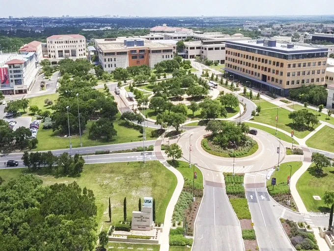 Aerial view of the University of Texas at San Antonio campus, featuring several buildings and a roundabout.