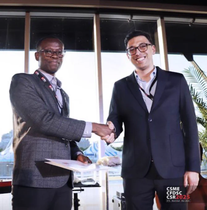 Two men in business attire shake hands infront of a large glass window