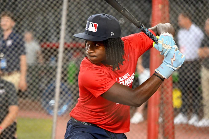 Photo of Anthony Pack Jr. taking batting practice in a red Draft Combine shirt