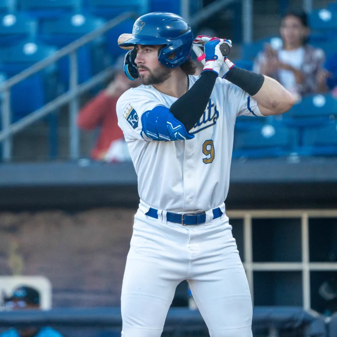 Blake Mitchell bats in a white Quad Cities River Bandits uniform and blue helmet