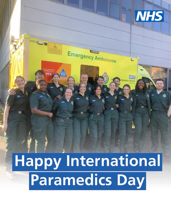 Group of paramedics standing in front of an ambulance with text stating "Happy International Paramedics Day".