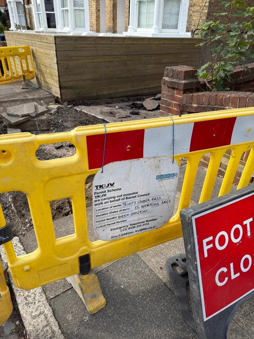 A yellow construction works barrier with a sign informing residents of works. 