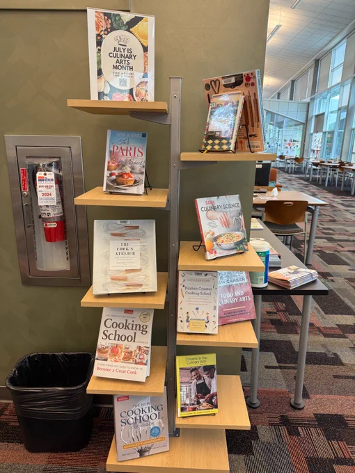 Freestanding book display with books about culinary arts.