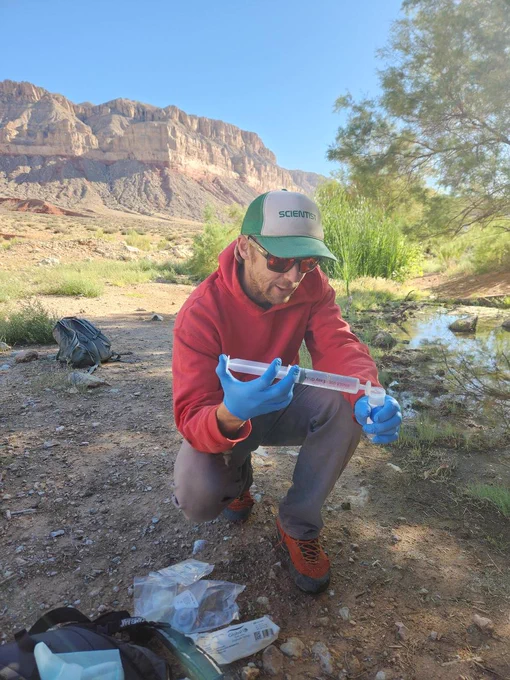 Zach Harrison collects a water quality sample at Willow Spring, AZ. Photo courtesy of Kat Cooney, USGS AZ Water Science Center.