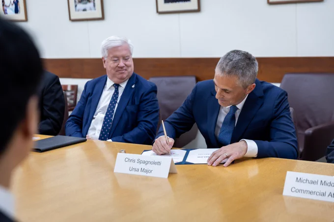 Ambassador Glass looks on as Chris Spagnoletti from Ursa Major signs agreement