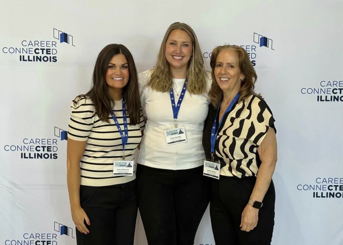 team members standing together in front of career connected illinois sign at conference
