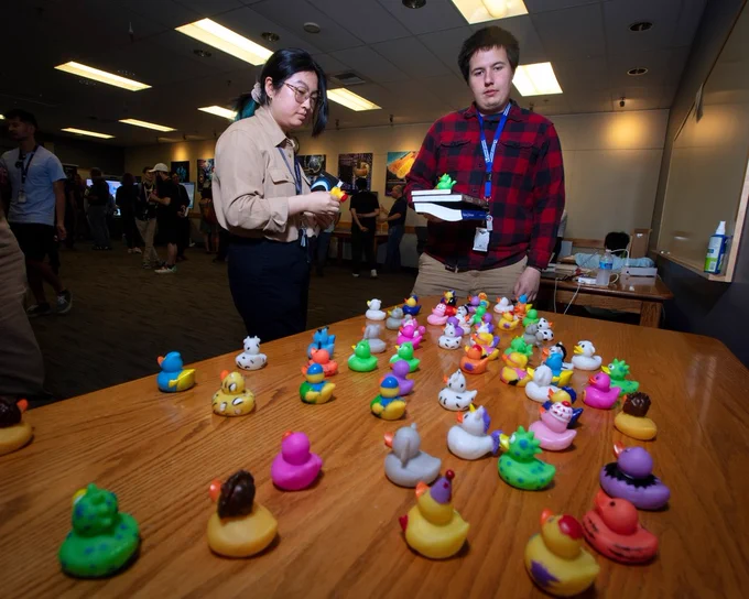 Dev Day participants looking at a table of colorful rubber ducks