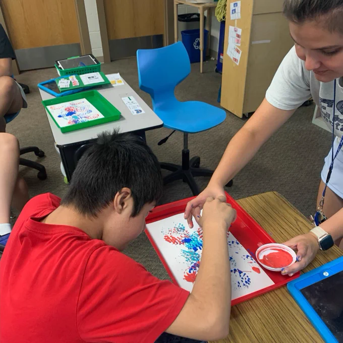 students participating in activities in the classroom including building blocks, foam, and coloring