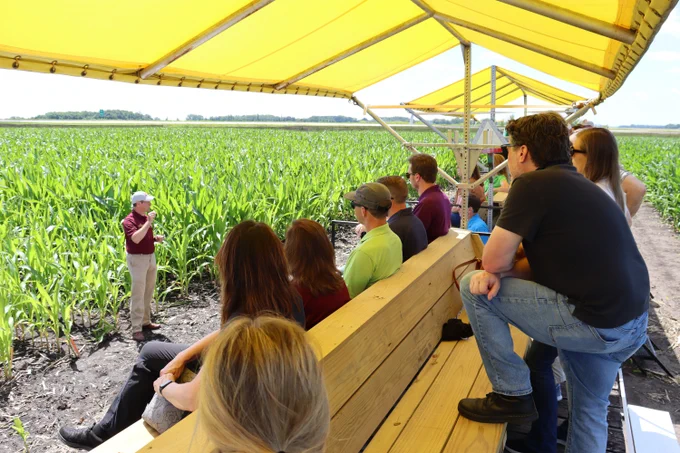 Fabian Fernandez speaks to a group of field day attendees in a corn field.