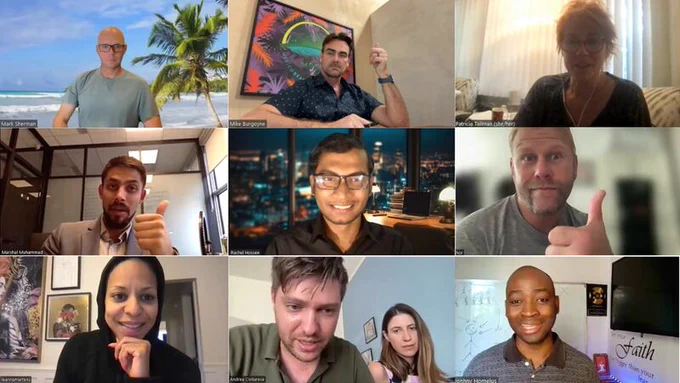 Person on a Zoom call with clients, smiling and giving thumbs-up, showing attentive and confident engagement during a professional meeting.
