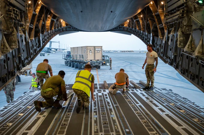 U.S. Airmen and Royal Air Force Service Personnel flip cargo rollers inside a C-17 Globemaster III assigned to 99 Squadron, Royal Air Force Brize Norton after offloading cargo within the U.S. Central Command area of responsibility, April 12, 2025. (U.S. Air Force photo by Senior Airman Amanda Jett)