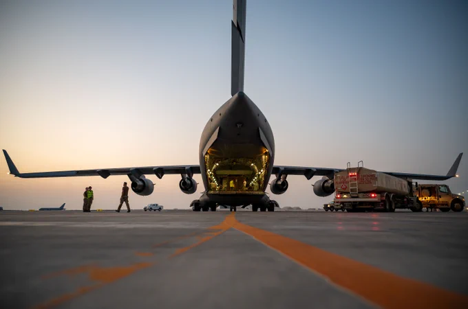 A C-17 Globemaster III from 99 Squadron, Royal Air Force Brize Norton is refueled by US Airmen on a flightline within the U.S. Central Command area of responsibility, April 12, 2025.  (U.S. Air Force photo by Senior Airman Amanda Jett)