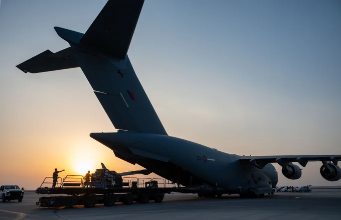 US Airmen and Royal Air Force Service Personnel offload cargo from a C-17 Globemaster III assigned to 99 Squadron RAF Brize Norton within the U.S. Central Command area of responsibility, April 12, 2025.  (U.S. Air Force photo by Senior Airman Amanda Jett)