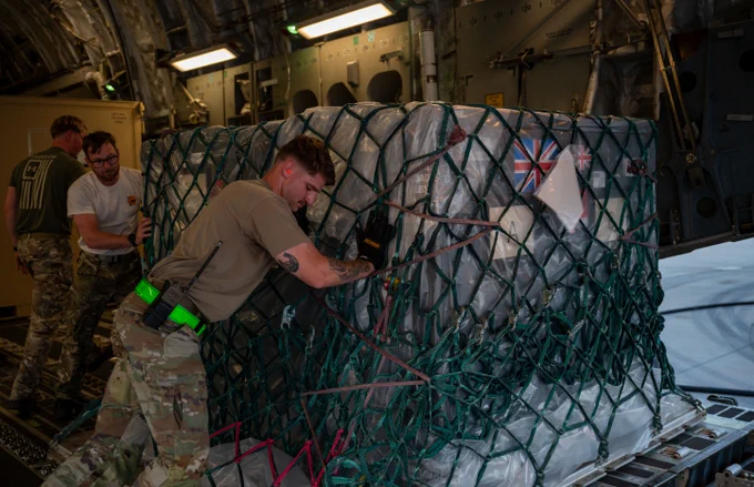 US Airmen and Royal Air Force Service Personnel offload cargo from a C-17 Globemaster III assigned to 99 Squadron, Royal Air Force Brize Norton within the U.S. Central Command area of responsibility, April 12, 2025.  (U.S. Air Force photo by Senior Airman Amanda Jett)