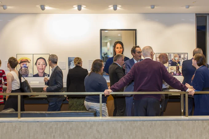 A view of the exhibition gallery full of visitors.