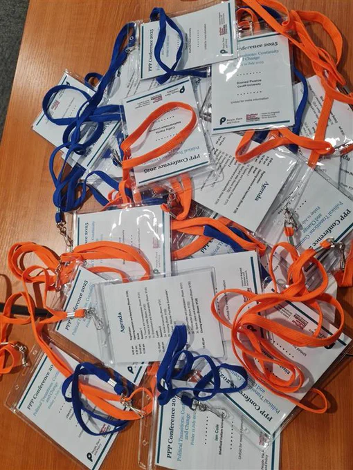 A pile of conference lanyards on a desk
