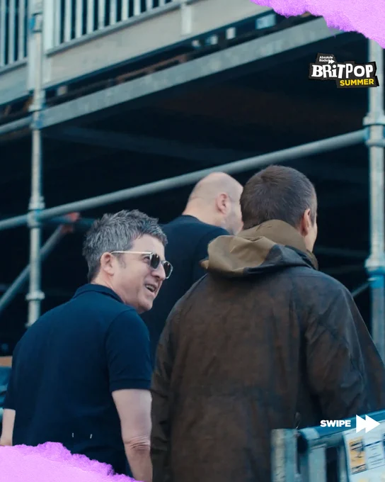 Liam and Noel Gallagher smiling at each other