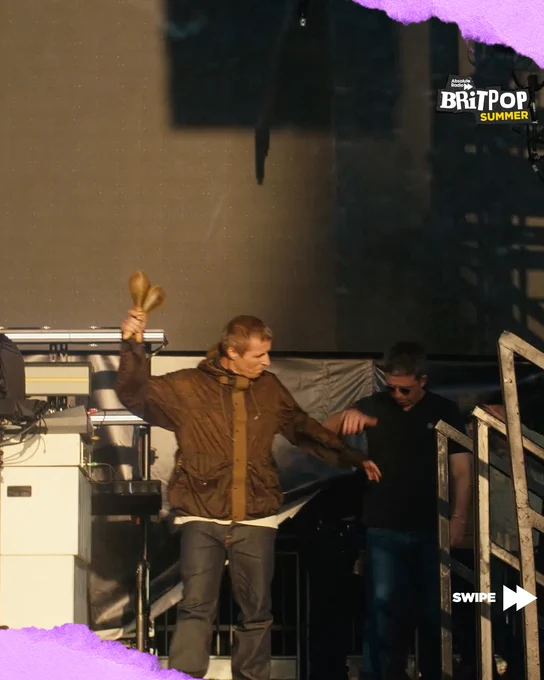 Liam reaching for Noel's hand as they walk on stage