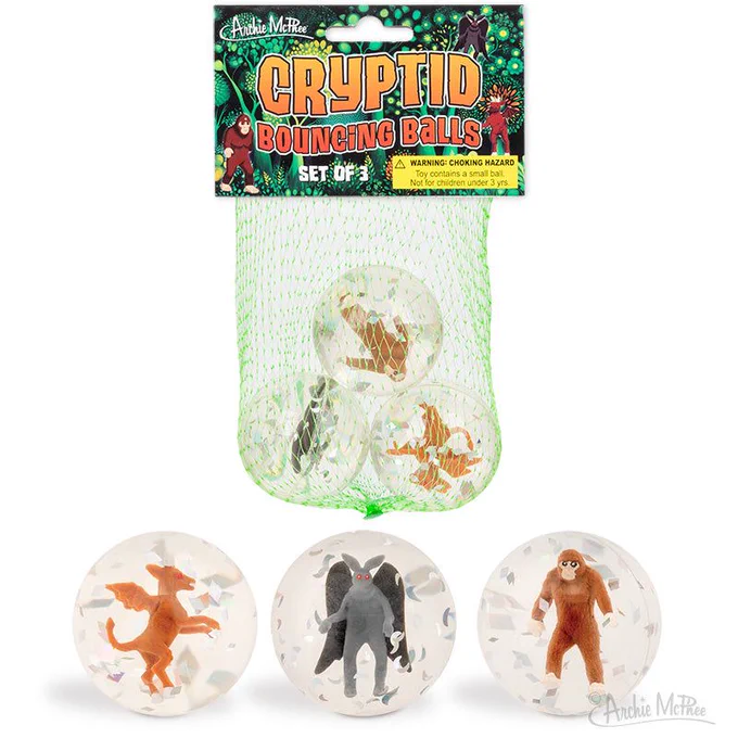 Three clear rubber balls with figures of cryptids inside. Bigfoot, Mothman and Jersey Devil 