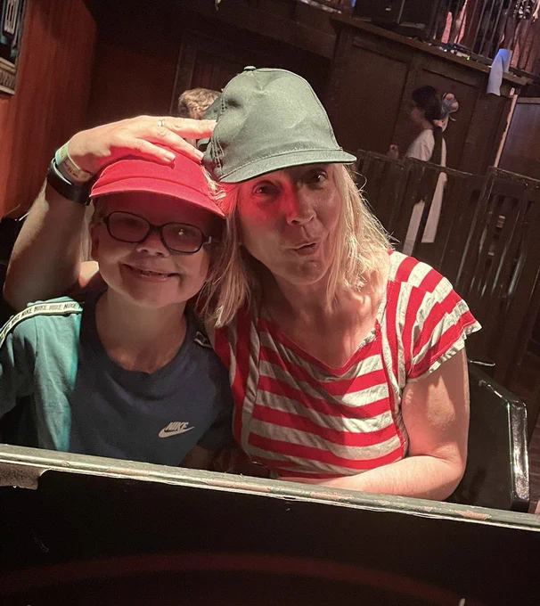 Woman and kid in baseball caps.