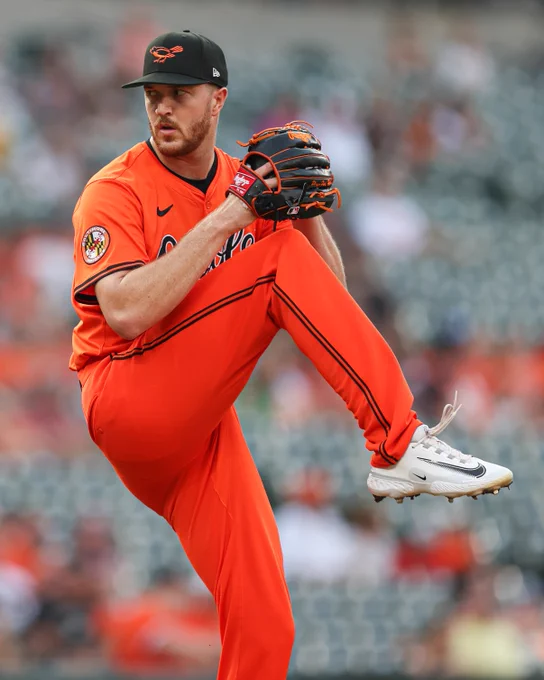 Trevor Rogers pitches from the mound at Oriole Park. He is wearing an all orange Orioles uniform and Hall of Fame Weekend Orioles cap.