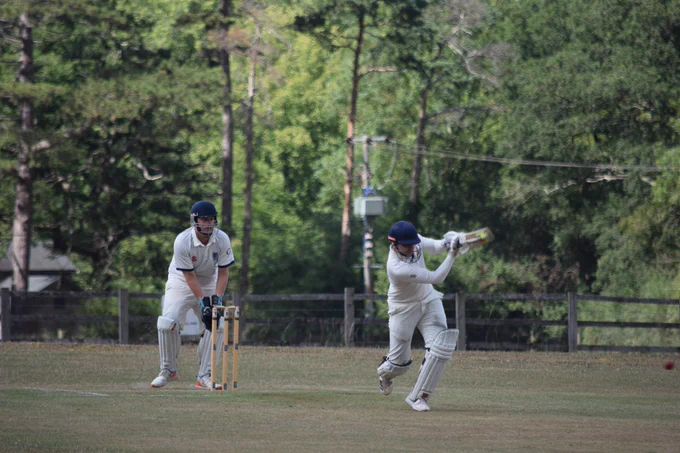 Luke dances down the wicket to strike the ball through the legside at the wicket keeper watches on
