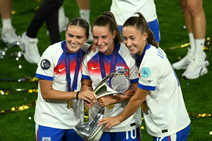 Grace Clinton, Ella Toone and Maya Le Tissier pose with the Euro 2025 trophy.