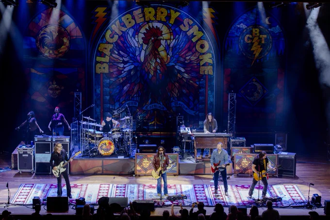 Wide shot of Blackberry Smoke singing and playing instruments on the Ryman stage