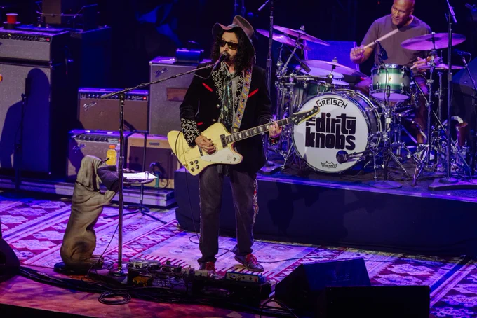 Close-up of Mike Campbell singing and playing guitar on the Ryman stage