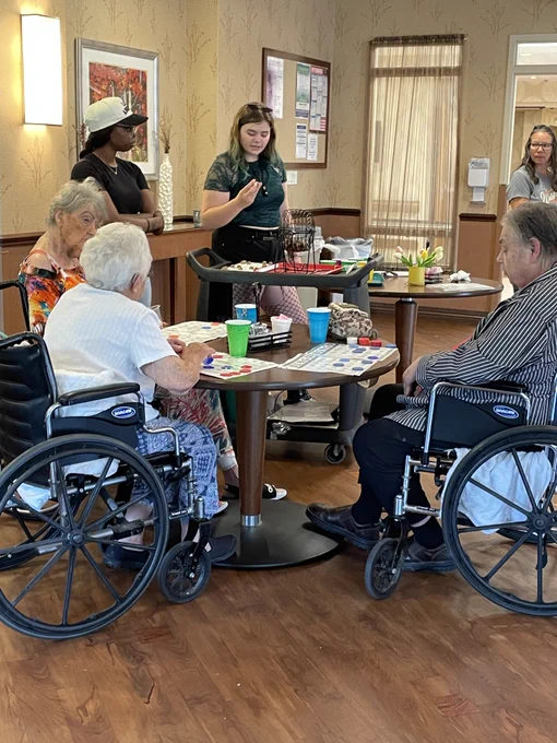 students engaging with elderly by playing bingo at local nursing home