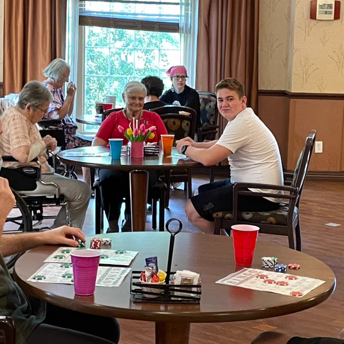students engaging with elderly by playing bingo at local nursing home