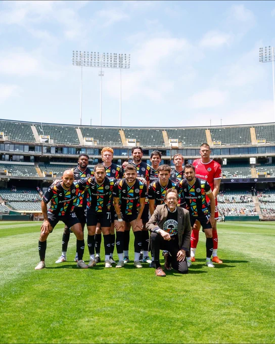 soccer team posing with BART director robert raburn on field 