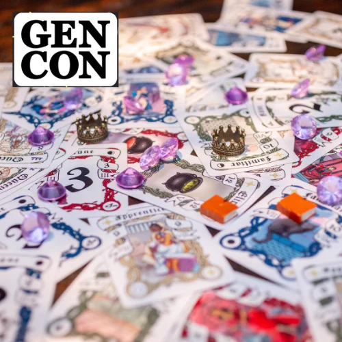 Photo of Castlore cards all mixed up, mostly out of focus, with several pink crystals, 2 orange book tokens, and 2 golden crowns on top of the cards, with a narrow depth of field focus on the crowns.