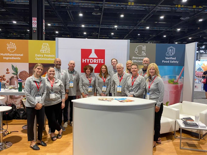 A large group of Hydrite employees wearing matching apparel stand in the Hydrite booth at 2025 IFT FIRST in Chicago.