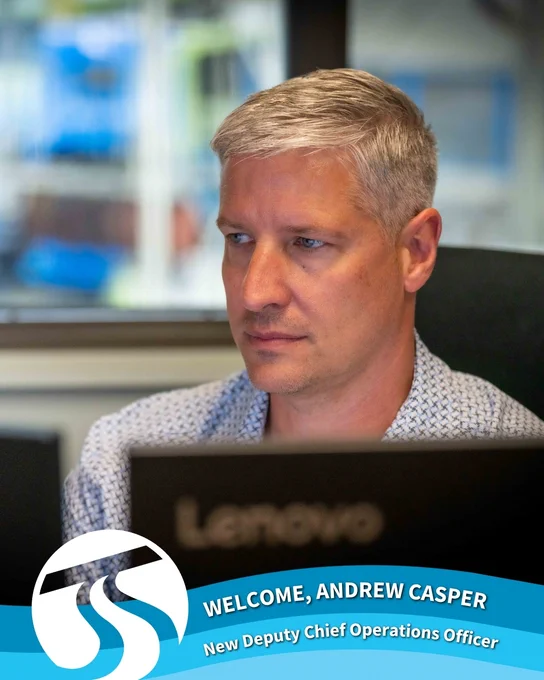 Andrew Casper, Spokane Transit’s new Deputy Chief Operations Officer, is focused while working at a computer. He’s seated in front of a Lenovo monitor, wearing a light blue patterned shirt. A Spokane Transit logo and welcome banner at the bottom reads: “Welcome, Andrew Casper – New Deputy Chief Operations Officer.”