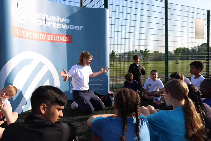 Team GB hockey player and sports inclusivity trailblazer Tess Howard MBE with school children