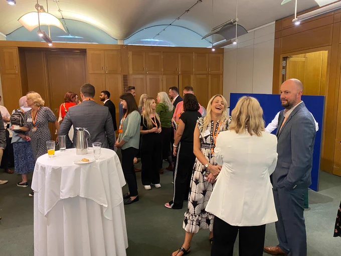 A room of people, discussing informally in small groups.