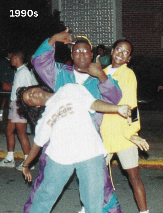 Three individuals are dancing enthusiastically on a street, dressed in colorful 1990s fashion.