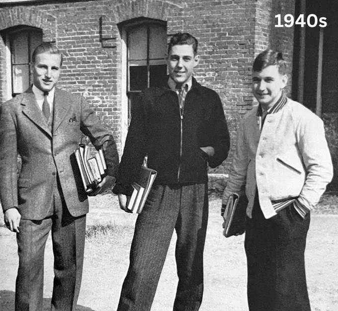 Three men holding books stand outside a brick building in the 1940s.