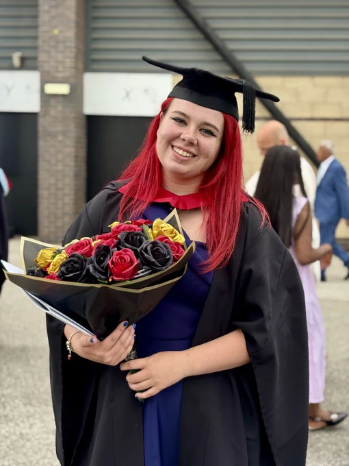 Graduate holding flowers