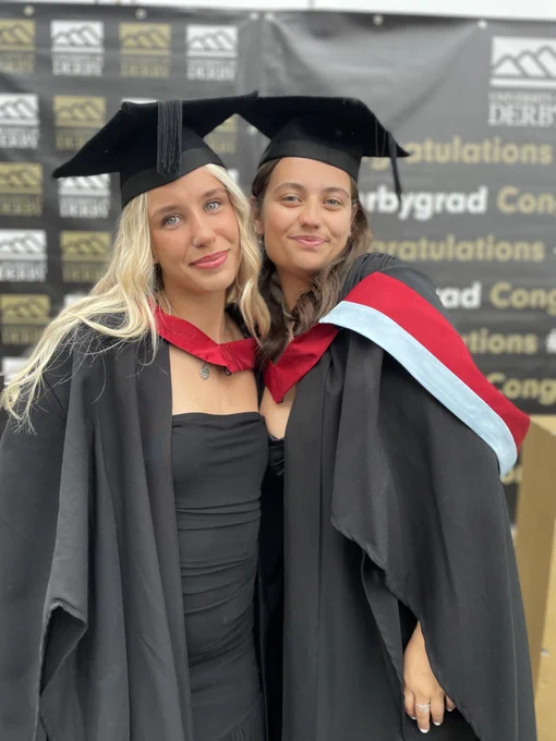 Two graduates smiling