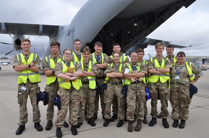 12 air cadets in greens and high vis jacket outside back of RAF A400M with ramp down.